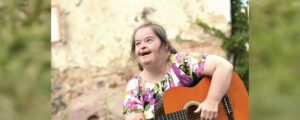 Girl playing guitar. Girl has Down Syndrome