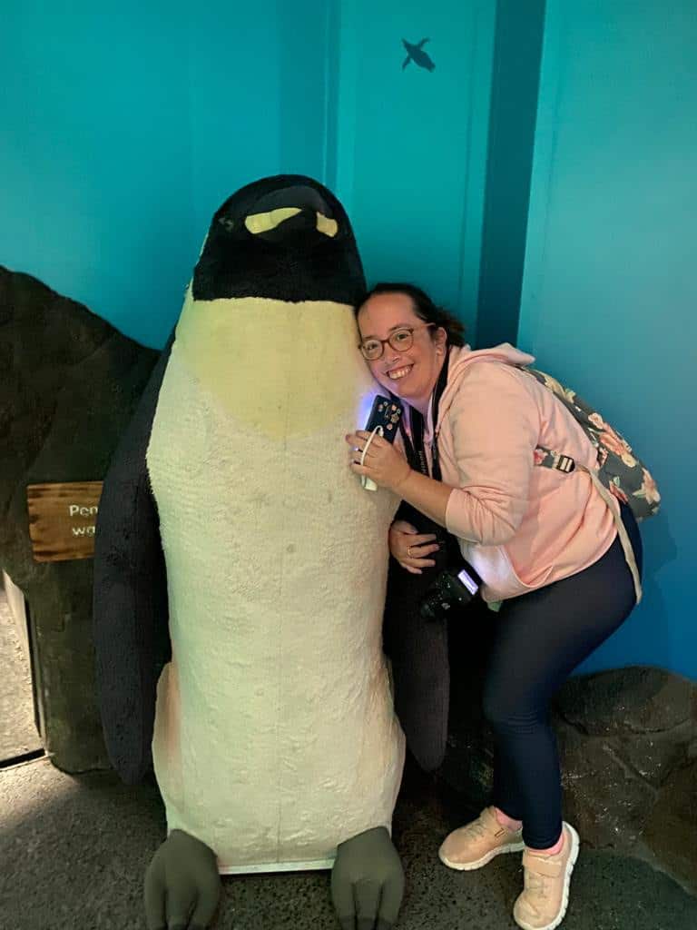 Rebecca cuddling a giant toy penguin